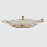 Decorative ceramic dish with floral patterns and gold handles on a light gray background