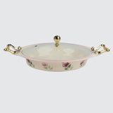 Decorative ceramic dish with floral patterns and gold handles on a white background