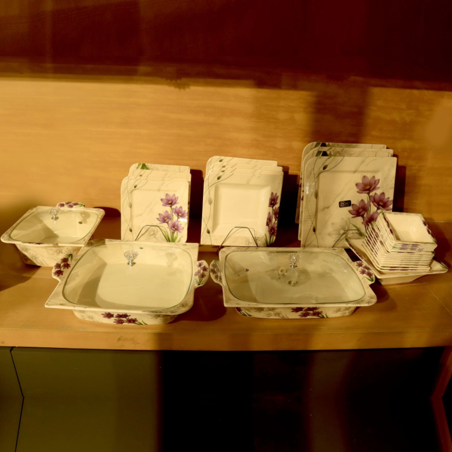 Set of ceramic dishes with floral patterns on a wooden surface.