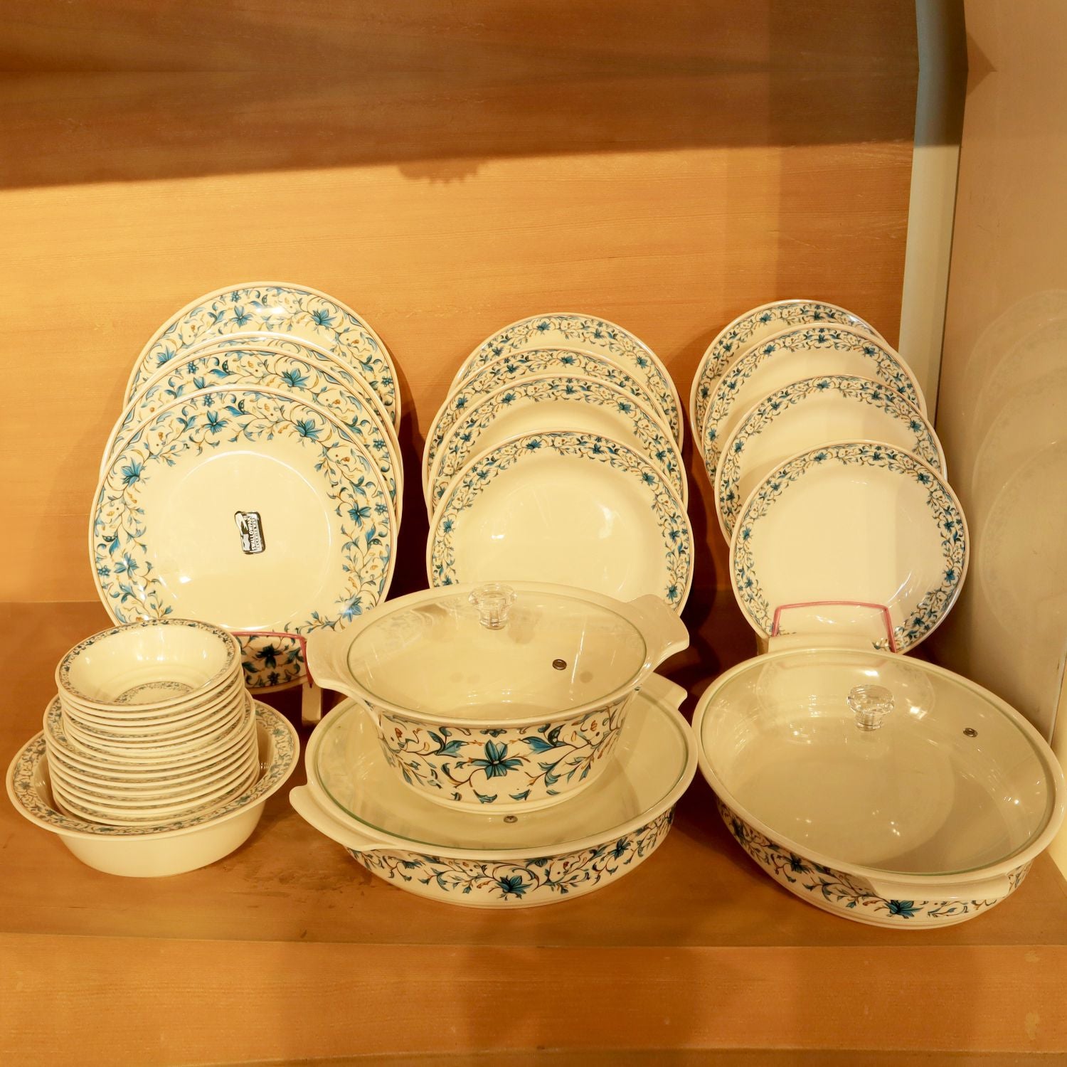 Set of ceramic dishes with floral patterns on a wooden surface