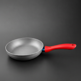 Majestic Chef  silver aluminum frying pan with a bright red handle, shown on a dark gray background.

