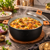 Nonstick biryani pot filled with spiced rice, glass lid, wood-texture handles